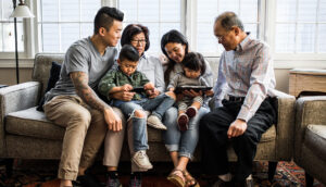 3 generations on couch looking at tablet